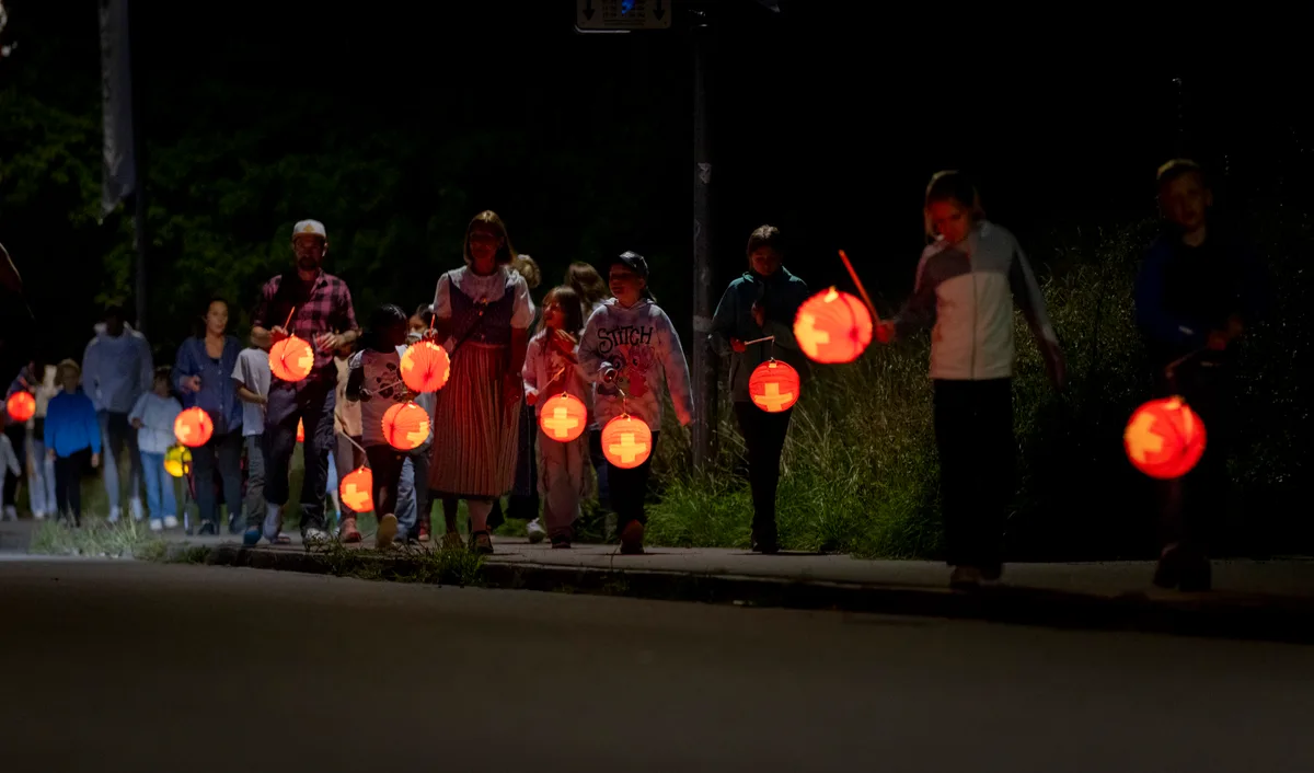 Der Lichterumzug machte gross und klein Spass. Mehrere Leute tragen ein Lampion vor sich her.